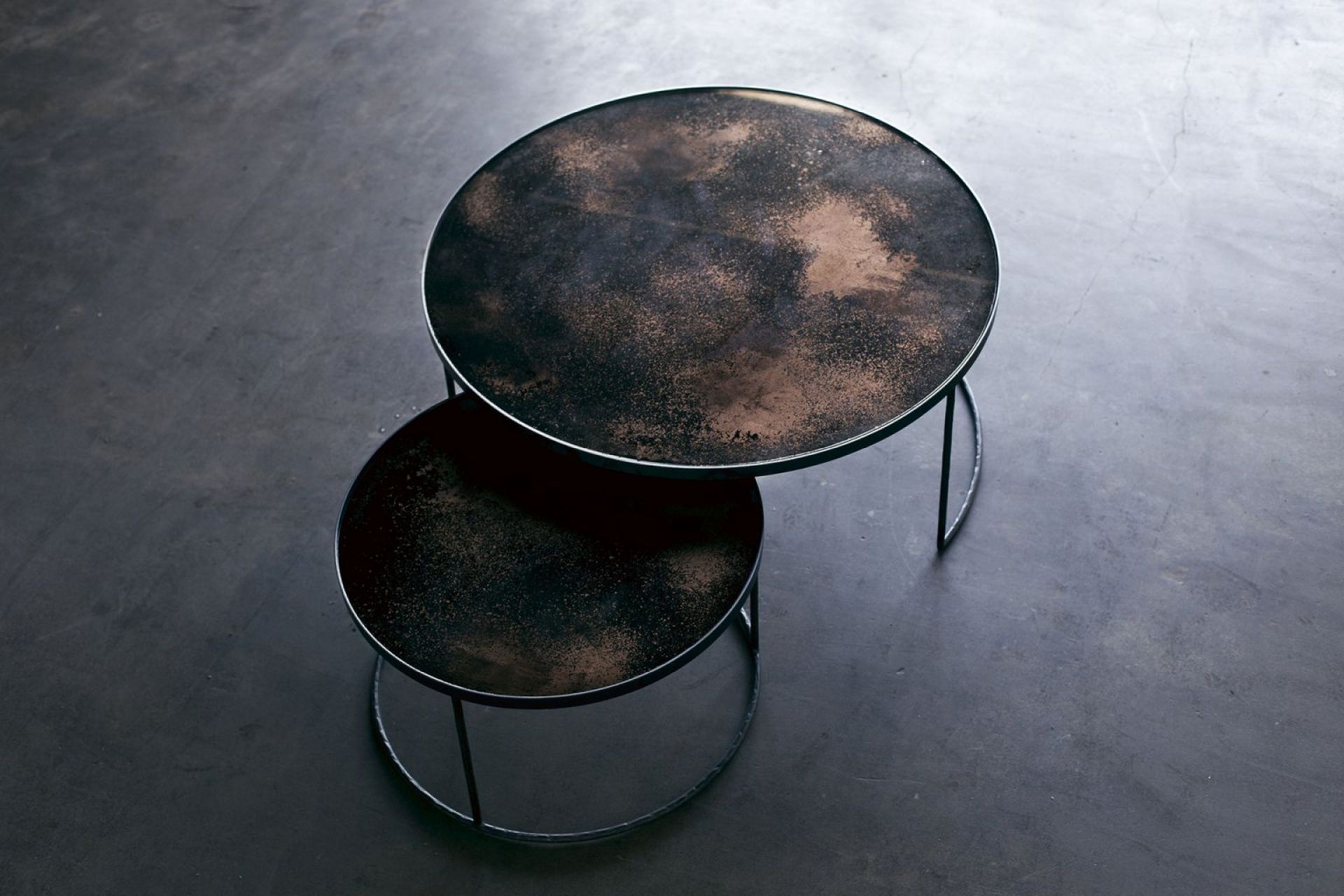 Nesting Couchtische 2er Set von Ethnicraft in Bronze, runde Tischplatten mit dunkler, strukturierter Oberfläche.